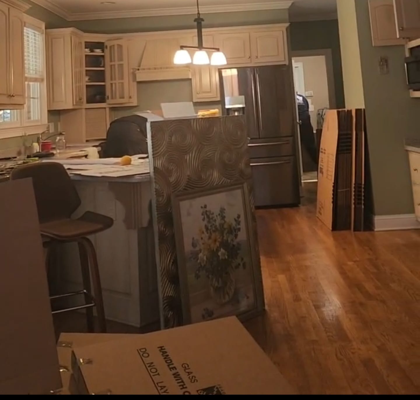 Kitchen during a home transition, with furniture and packed items ready to move